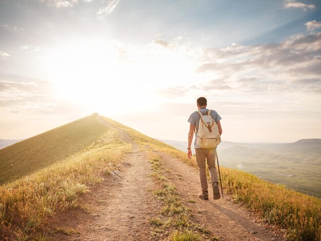 Un jeune homme voyage seul sur fond de montagnes