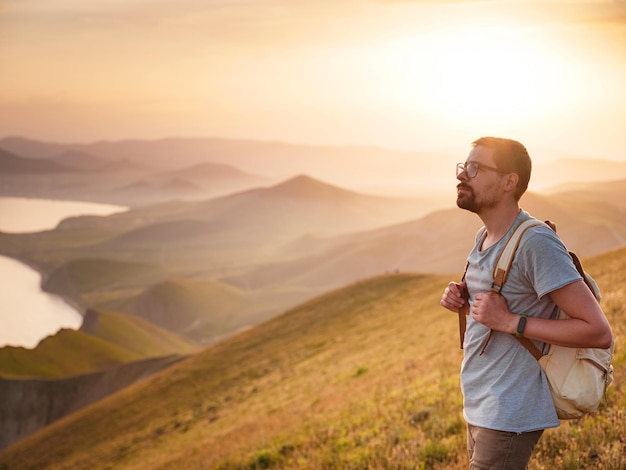 Un jeune homme voyage seul sur fond de montagnes