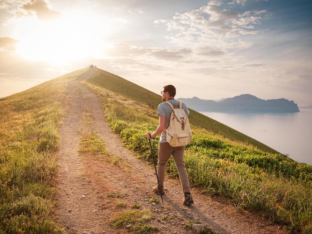 Un jeune homme voyage seul sur fond de montagnes