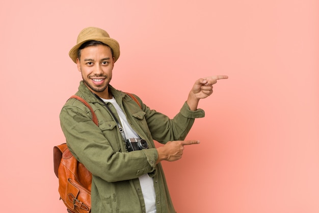 Photo jeune homme voyageur philippin excité pointant avec les index loin.