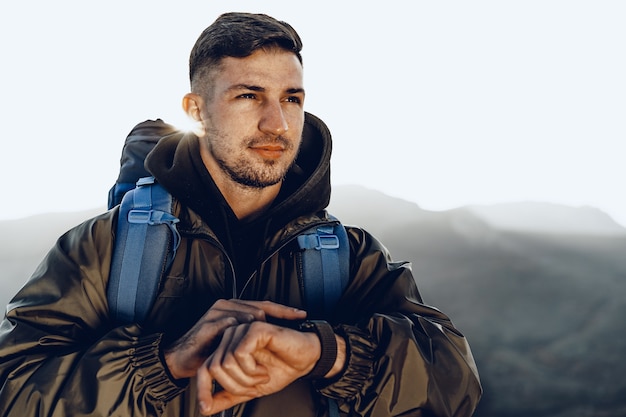 Jeune homme voyageur regardant sa montre intelligente