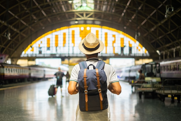 Photo jeune homme voyageur avec sac à dos en attente de train