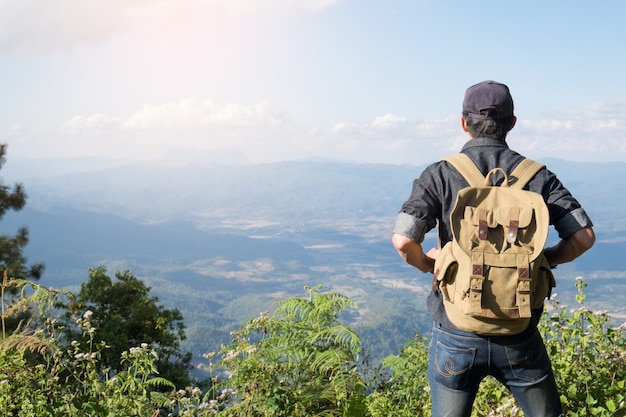 Jeune homme Voyageur avec sac à dos relaxant en plein air avec des montagnes rocheuses en arrière-plan Idées de vacances d&#39;été et de style de vie