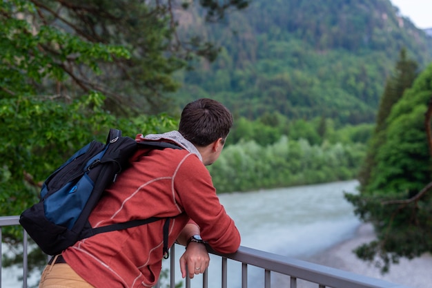 Jeune homme voyageur se tient près de l'escrime