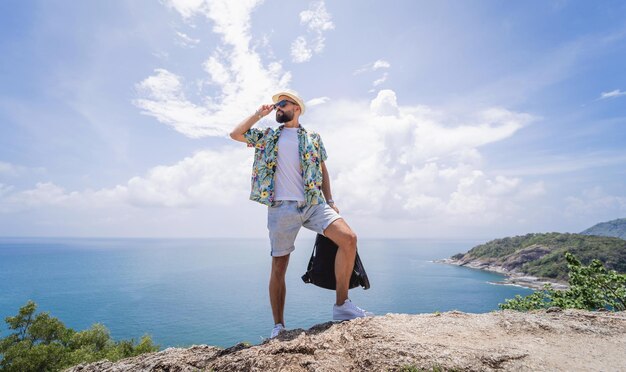 Jeune homme voyageur en vacances d'été avec de belles montagnes et des paysages marins en arrière-plan