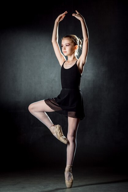 Jeune et incroyablement belle ballerine posant et dansant en studio. Danseuse de ballet.
