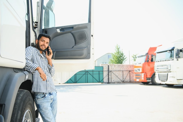 Un jeune Indien debout près de son camion Le concept de transport de marchandises