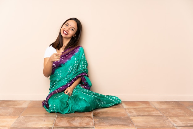 Jeune, indien, femme, séance, plancher, pointage, devant, heureux, expression