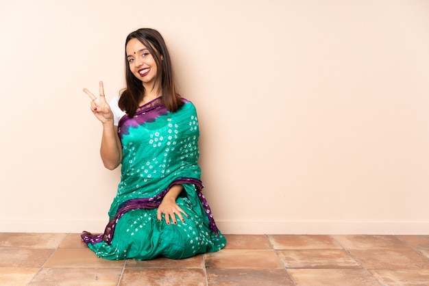 Jeune, indien, femme, séance, plancher, Sourire, projection, victoire, signe