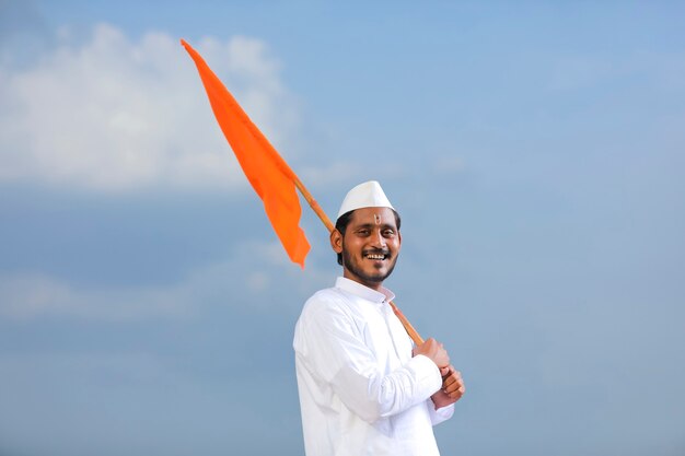 Jeune indien (pèlerin) en tenue traditionnelle et agitant un drapeau religieux.