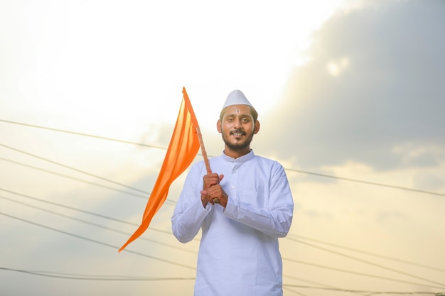 Jeune indien (pèlerin) en tenue traditionnelle et agitant un drapeau religieux.