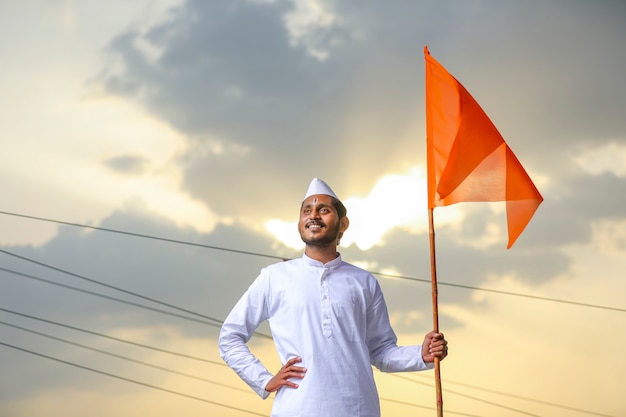 Jeune indien (pèlerin) en tenue traditionnelle et agitant un drapeau religieux.