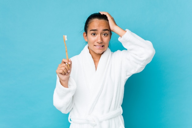 Jeune indienne métisse tenant une brosse à dents choquée, elle se souvient d'une rencontre importante.