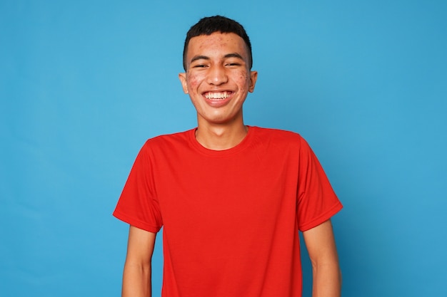 Jeune indonésien souriant sur fond bleu