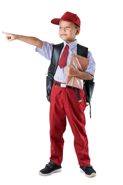 Un jeune Indonésien en uniforme rouge et blanc pointe vers l'avant en tenant un livre.