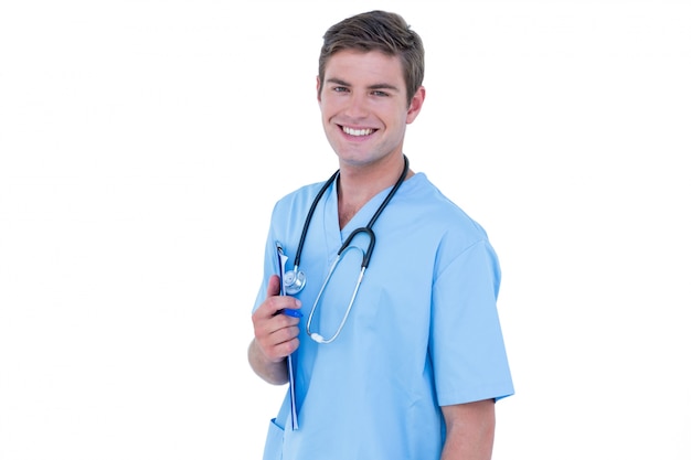 Jeune infirmière en tunique bleue, souriant à la caméra