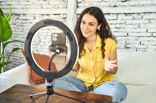 Une jeune influencer caucasienne enregistre créativement un vlog sur elle