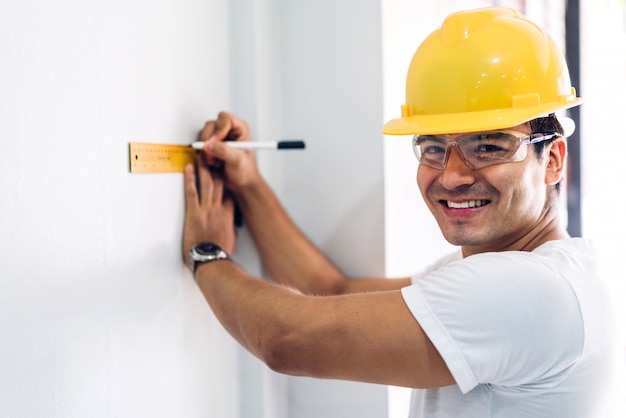 Jeune Ingénieur En Construction Dans Un Casque Jaune, Travaillant Et Cherchant Un Emploi Pour La Planification D'un Projet Sur Le Site Du Bâtiment