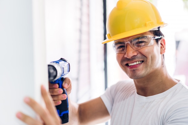 Jeune ingénieur en construction dans un casque jaune travaillant