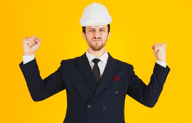 Un jeune ingénieur est en colère contre un costume et un casque.