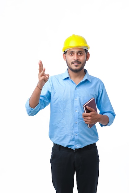 Jeune ingénieur indien ou étudiant portant un casque sur fond blanc.