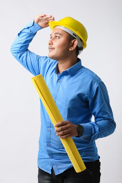 Jeune ingénieur indien portant un casque de couleur jaune et donnant un geste réussi.