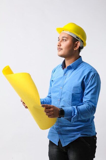 Jeune ingénieur indien portant un casque de couleur jaune et donnant un geste réussi.