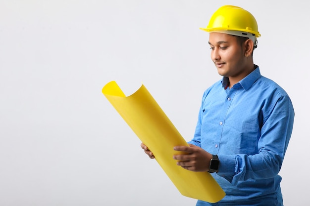 Jeune ingénieur indien portant un casque de couleur jaune et donnant un geste réussi.