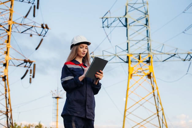 Un jeune ingénieur inspecte et contrôle l'équipement de la ligne électrique. Énergie.