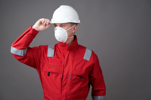 Jeune ingénieur travailleur porte un casque, un masque facial