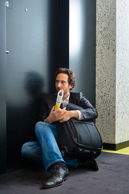 Jeune invité devant la porte de la chambre d'hôtel