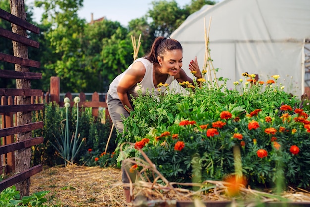 Jeune jardinier dans le jardin sentant la fleur