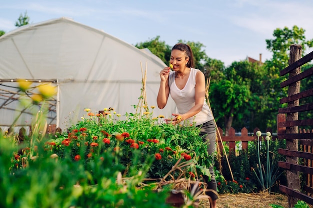 Jeune jardinier dans le jardin sentant la fleur