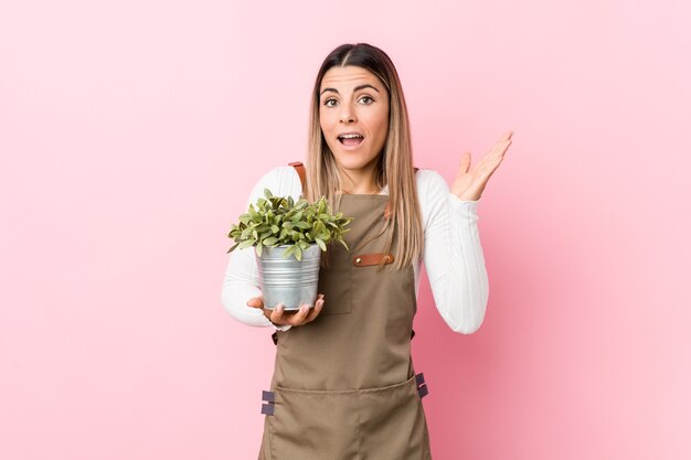 Jeune jardinier femme tenant une plante