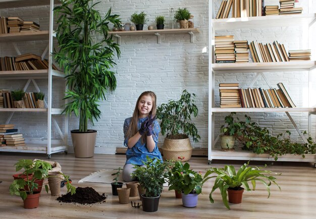 Une jeune jardinière s'occupe des plantes et des fleurs de la maison