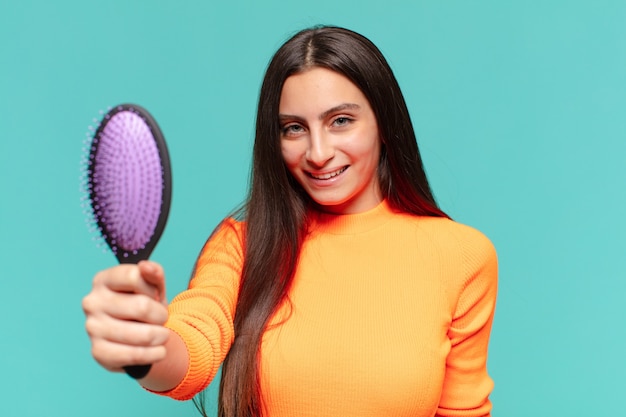 Jeune jolie adolescente. expression heureuse et surprise. concept de brosse à cheveux