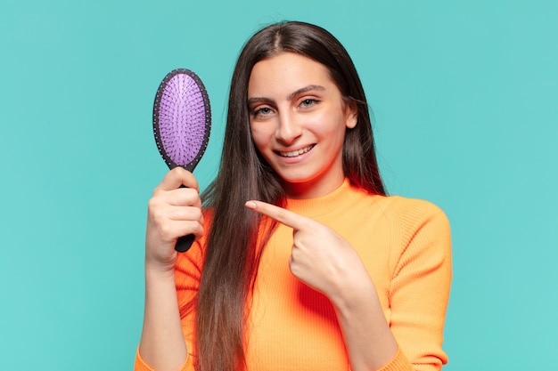 Jeune jolie adolescente. geste de pointage. concept de brosse à cheveux