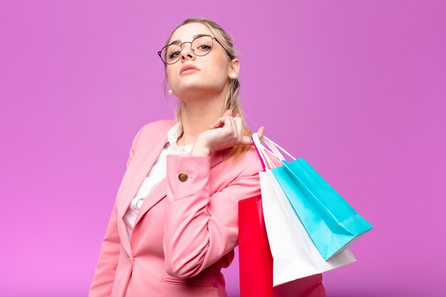 Jeune jolie blonde femme tenant des sacs à provisions