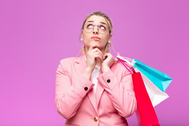 Jeune jolie blonde femme tenant des sacs à provisions