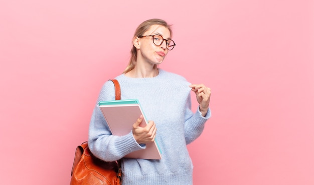 Jeune jolie étudiante à l'air arrogante, réussie, positive et fière, se montrant elle-même