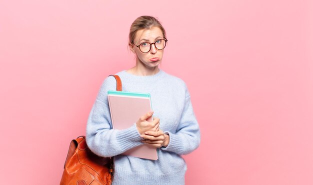 Jeune jolie étudiante se sentant triste et geignarde avec un regard malheureux, pleurant avec une attitude négative et frustrée