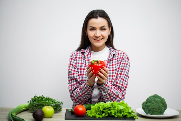 Jeune jolie femme adhère au régime alimentaire et détient des légumes