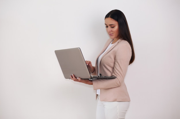 Jeune jolie femme d'affaires avec ordinateur portable au bureau