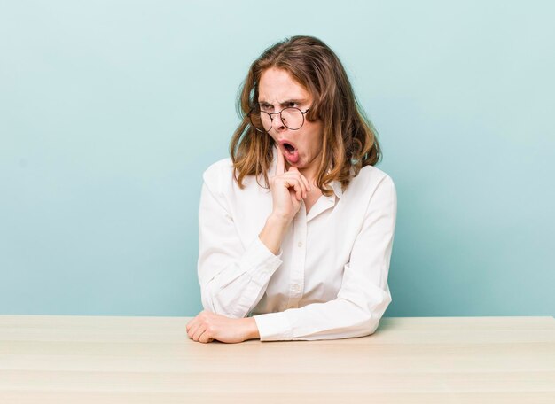 Jeune jolie femme d'affaires s'asseyant avec une table