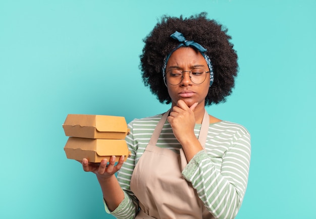 Jeune jolie femme afro livrer avec un burger à emporter