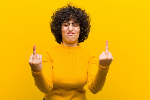 Photo jeune jolie femme afro se sentant provocante, agressive et obscène, renversant le majeur, avec une attitude rebelle