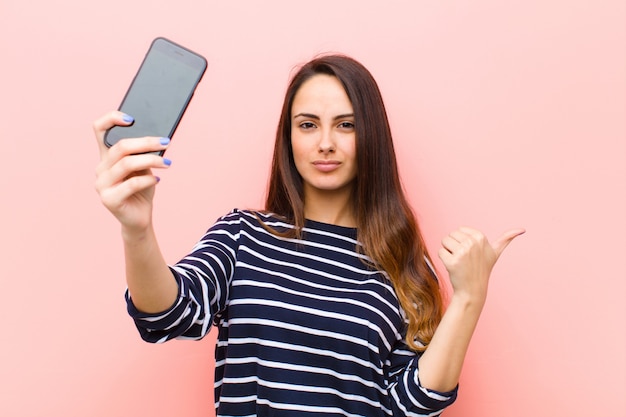 Jeune jolie femme à l'aide de son téléphone intelligent