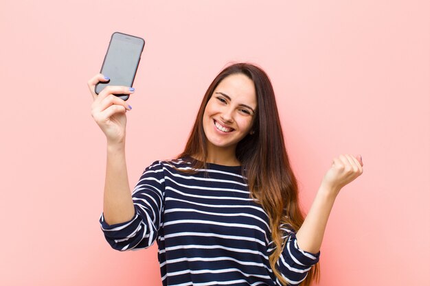 Jeune jolie femme à l'aide de son téléphone intelligent