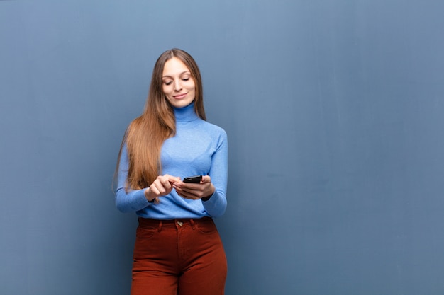 Jeune jolie femme à l'aide d'un téléphone intelligent