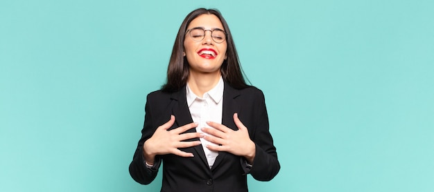 Jeune jolie femme à l'air heureuse, surprise, fière et excitée, se montrant elle-même. concept d'entreprise